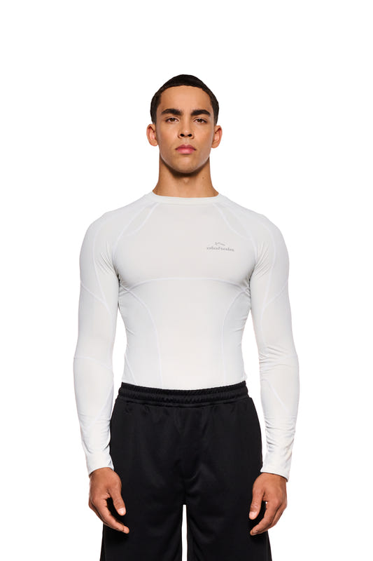 A man wears the Sports Anatomy Tech Top Gray with decorative stitching and OLAKALA Sports logo on the chest; slim fit, unisex.