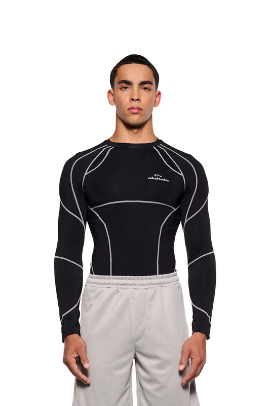 Mann trägt das Sports Anatomy Tech Top Black mit OLAKALA Logo auf der Brust, betont durch Ziernähte, eng anliegendes Longsleeve-Design.