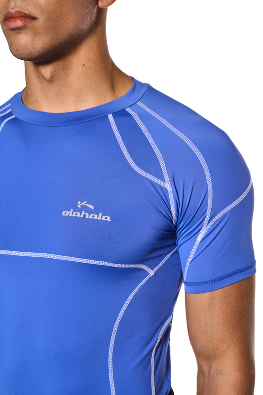 Mann trägt das Sports Anatomy T-Shirt Blau mit Ziernähten und OLAKALA Logo auf der Brust, enganliegende Passform, unisex Design.