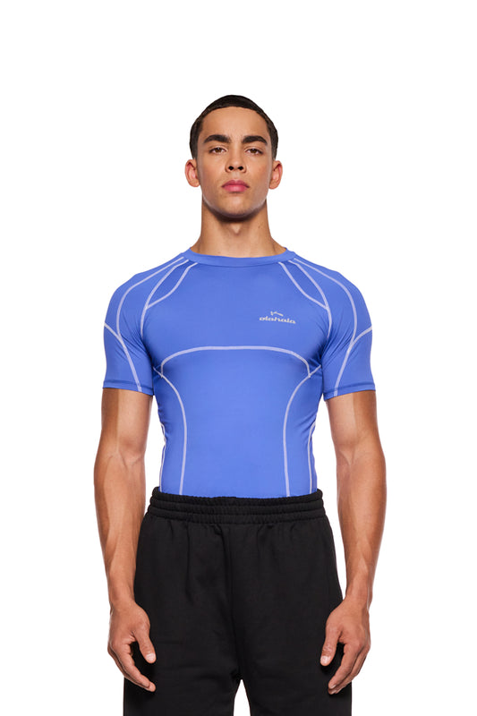 Ein Mann trägt das Sports Anatomy T-Shirt Blau mit Ziernähten und OLAKALA Sports Logo auf der Brust, eng anliegende Passform. Unisex Design.