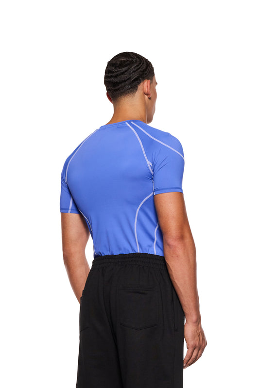 Mann von hinten in blauem Sports Anatomy T-Shirt. Enganliegende Passform mit OLAKALA Logo auf der Brust, sichtbare Ziernähte.