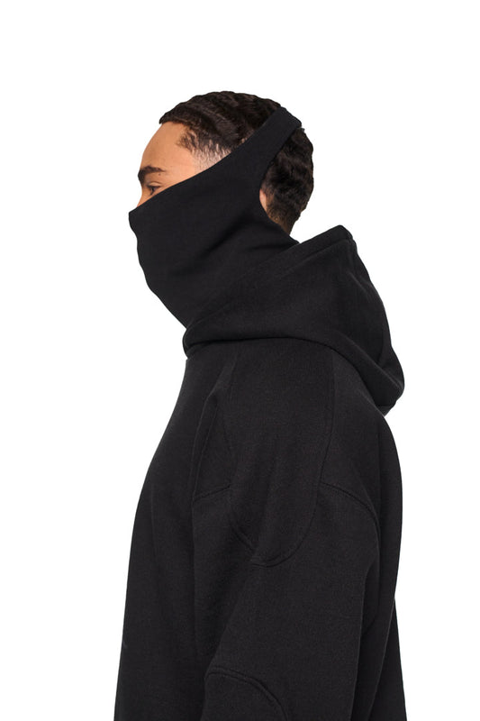 Person trägt Alien Intel Mask Hoodie mit Rippbündchen, elastischem Bund, Kapuze und grauem Siebdruck. Oversized, cropped Fit, unisex Design.
