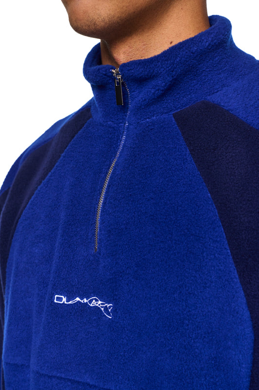 Alien Intel Fleece Halfzip Blue mit hohem Kragen, Reißverschluss, elastischen Bündchen und gesticktem „Synergy“-Logo, aus weichem Fleece-Stoff, oversized Passform.