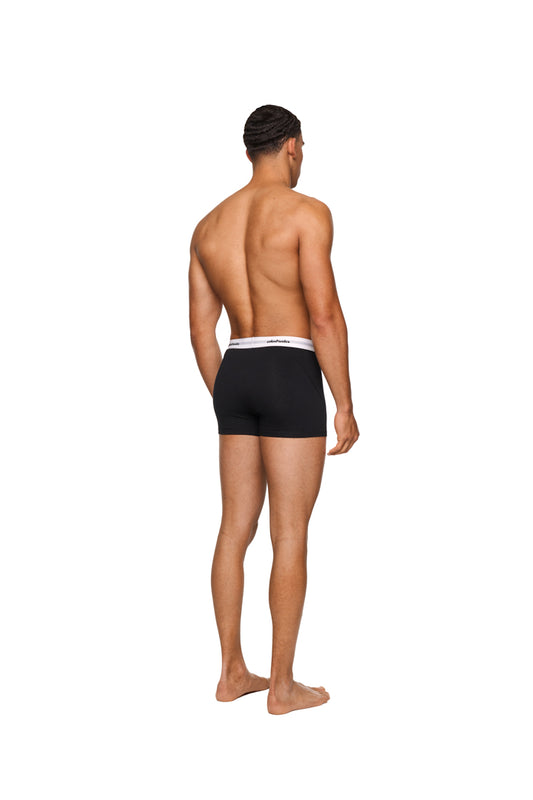 Mann trägt CC Boxershorts Black 3er Pack mit elastischem Bund und eingewebtem Logo, Trunk-Schnitt, Rückansicht. Produkt von OLAKALA Onlineshop, Rückgabe ausgeschlossen.