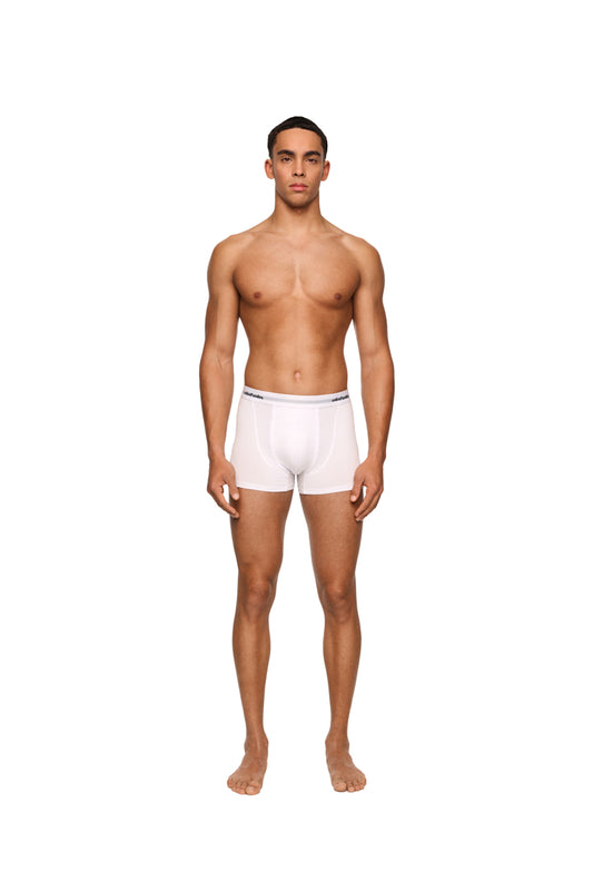 Ein Mann trägt weiße CC Boxershorts im 3er Pack mit elastischem Bund und eingewebtem Logo, präsentiert von OLAKALA.
