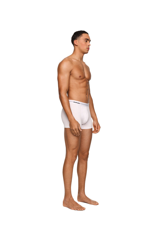 Mann in weißen CC Boxershorts, 3er Pack, mit elastischem Bund und eingewebtem Logo, präsentiert die Passform der OLAKALA Trunks.