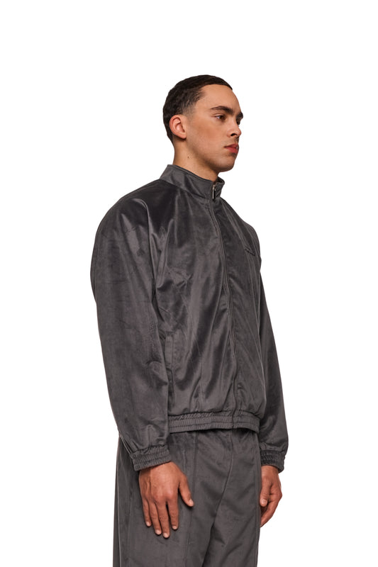 Mann in schwarzer Jacke zeigt sportlich-modernen Look der Sports Velour Jacket Gray mit Teilungsnähten und elastischen Bündchen.