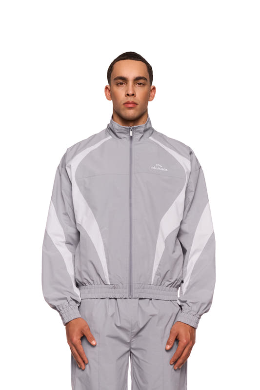 Mann trägt graues Sports Trackjacket mit gesticktem OLAKALA Sports Logo, elastischen Bündchen und atmungsaktivem Mesh-Futter für Komfort.