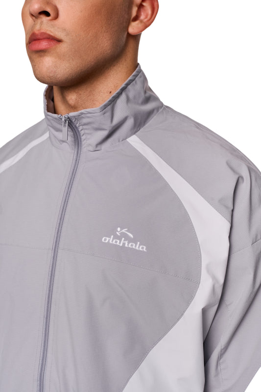 Sports Trackjacket Gray aus robustem Rip-Stop-Gewebe, atmungsaktivem Mesh-Futter, gesticktem OLAKALA Sports Logo auf der Brust, mit elastischen Bündchen.