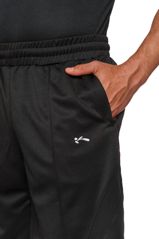 Person trägt Sports Performance Shorts Black mit elastischem Bund und Kordelzug, Eingriffstaschen mit Reißverschluss und gesticktem OLAKALA Sports Icon auf dem linken Bein.