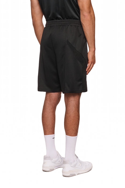 Ein Mann trägt Sports Performance Shorts Black mit elastischem Bund und Reißverschlusstaschen, kombiniert mit weißen Socken und Sneakers.