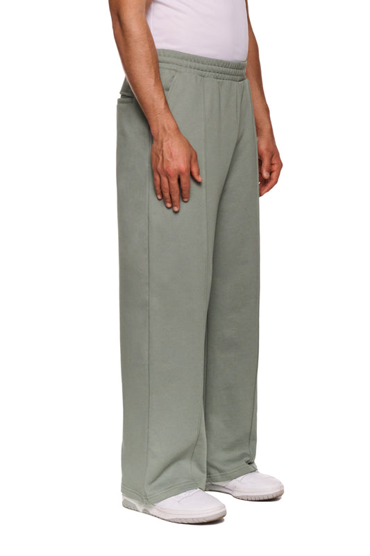 Person trägt weiche, locker sitzende OLAKALA Sports Loose Fit Sweatpants mit gesticktem Logo, elastischem Bund und offenem Beinabschluss, ideal für Komfort und Stil.