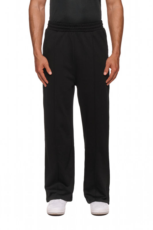 Person trägt Sports Loose Fit Sweatpants Black mit gesticktem OLAKALA Sports Logo, elastischem Bund und offenem Beinabschluss für entspannten Look.