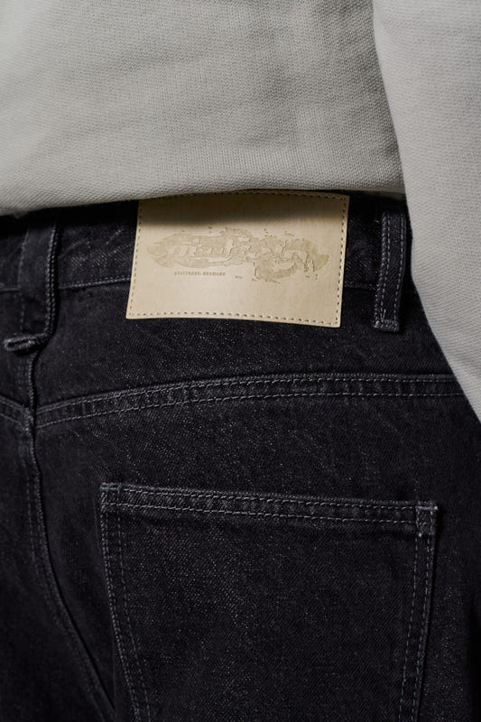 CC Black Loose Fit Denim Pants mit 5 Taschen, versetztem Hosenbund, geprägtem OLAKALA-Patch und gesticktem Logo, betont durch markante Details und lockere Passform.