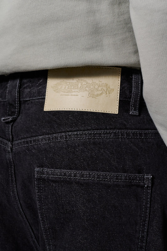CC Black Loose Fit Denim Pants mit 5 Taschen, versetztem Hosenbund, geprägtem OLAKALA-Patch und gesticktem Logo, betont durch markante Details und lockere Passform.