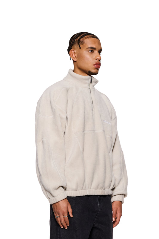 Mann trägt weißen CC Fleece Halfzip Pussywillow Gray mit elastischen Bündchen und gesticktem OLAKALA-Logo, hoher Kragen, Reißverschluss, oversized Unisex-Passform.