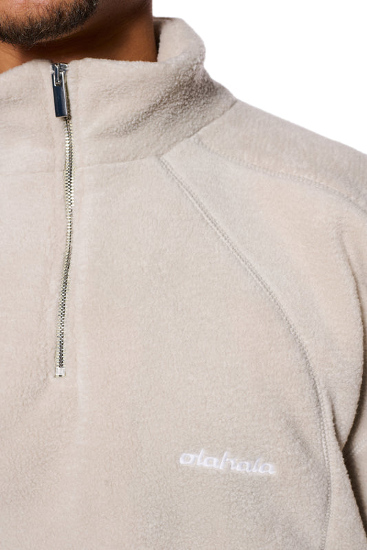 Nahaufnahme der CC Fleece Halfzip Pussywillow Gray Jacke mit gesticktem OLAKALA Logo, elastischen Bündchen und hohem Kragen, Reißverschluss an der Brust.
