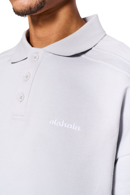 CC Polo Longsleeve Gray mit Polokragen und Knopfleiste, zeigt elastische Ärmelbündchen und gesticktes OLAKALA Logo auf der Brust. Unisex Oversized-Passform.