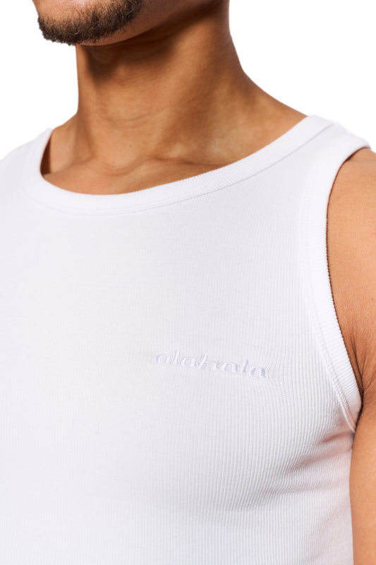 Person trägt ein CC Fine Rib Tanktop White mit gesticktem OLAKALA Logo auf der linken Brust; eng anliegende Passform und schwerer Ripp-Stoff.