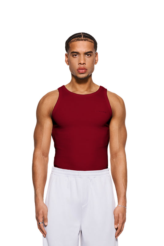Mann trägt eng anliegendes Rib Tanktop Rot mit gesticktem OLAKALA Logo auf der Brust und schwerem Ripp-Stoff.