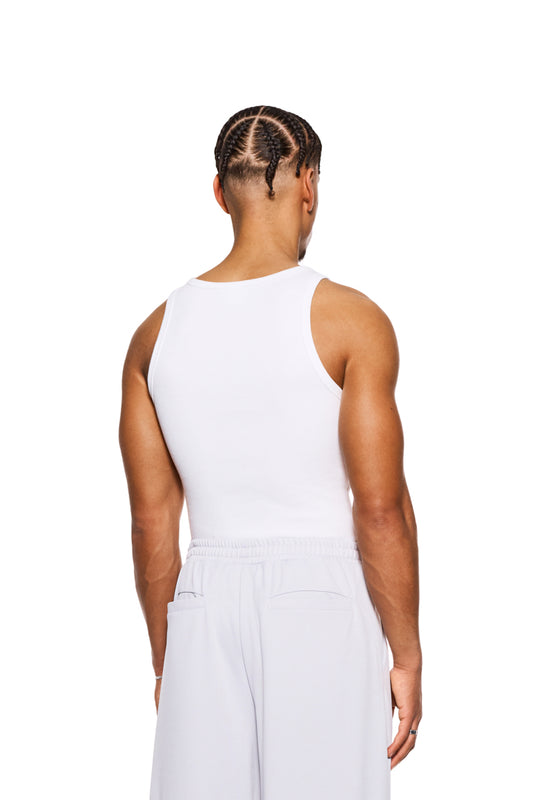Mann trägt eng anliegendes CC Fine Rib Tanktop Weiß mit gesticktem OLAKALA-Logo auf der Brust, aus schwerem Ripp-Stoff.