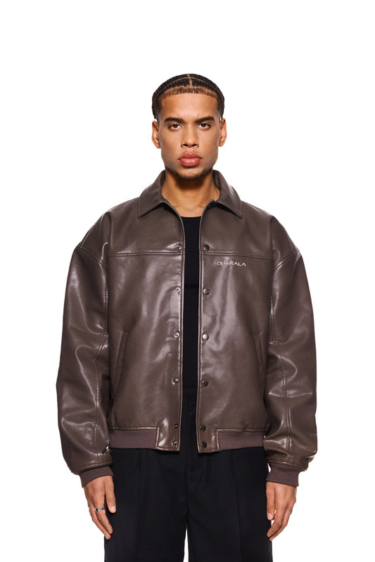 Ein Mann trägt die braune CC Lederjacke mit Reißverschluss, veganem Lederimitat und gesticktem OLAKALA Logo, betont durch praktische Taschen.