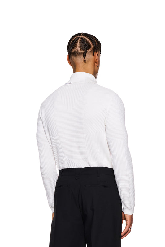Mann trägt Anatomy Turtleneck White, einen enganliegend gestrickten Rollkragenpullover mit OLAKALA-Tag am Kragen, präsentiert im offiziellen OLAKALA Onlineshop.