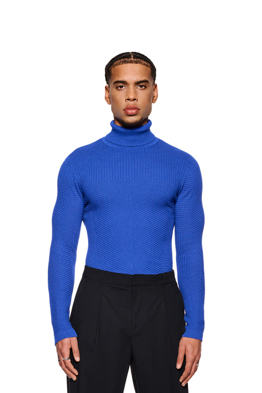 Man wearing Anatomy Turtleneck Blue with turtleneck and tight fit, part of the OLAKALA collection, showing knit pattern and OLAKALA tag on collar.