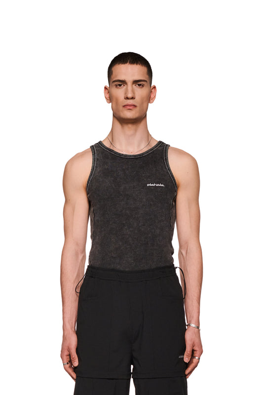 Mann trägt eng anliegendes Echoes Tanktop mit gesticktem OLAKALA-Logo auf der Brust und Teilungsnähten an den Seiten und Rücken.
