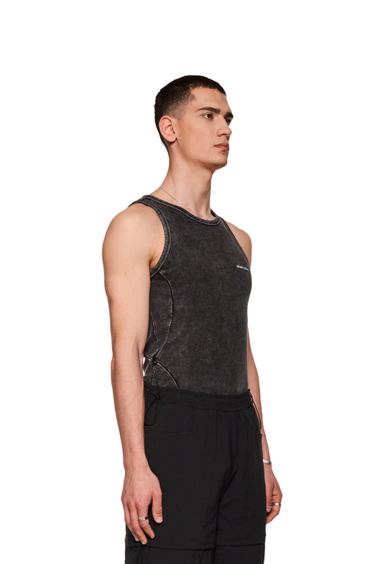 Mann trägt Echoes Tanktop mit gesticktem OLAKALA-Logo auf der Brust, betont durch Seitennähte und enge Passform in moderner Washed-Optik.