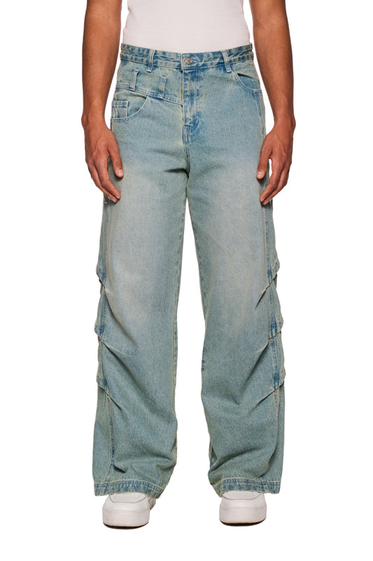 Person trägt Gills Washed Denim Pants Blue mit Kiemenoptik-Lufteinlässen, 5-Pocket-Design und OLAKALA-Logo auf der Vorderhose. Unisex, lockere Passform.
