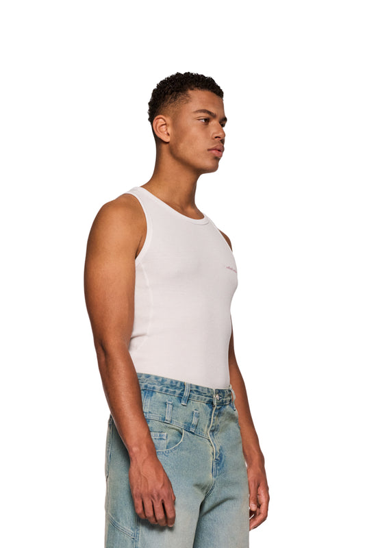 Mann im E.O.I Tanktop White mit gesticktem OLAKALA Logo auf der Brust, eng anliegendes Unisex-Design, Teilungsnähte an den Seiten sichtbar.