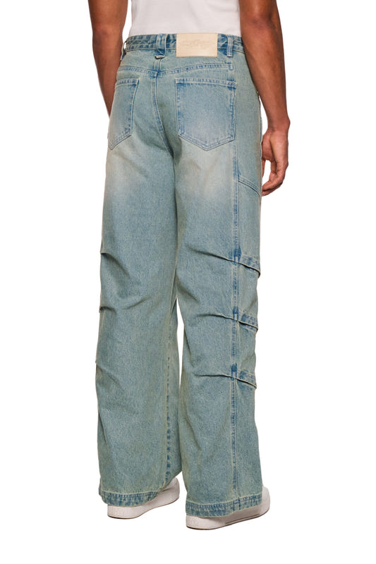 Person wears Gills Washed Denim Pants Blue with air vents on the sides, OLAKALA logo embroidery and 