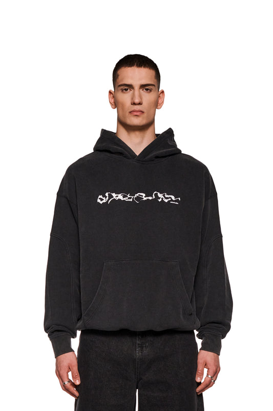Mann trägt E.O.I Hoodie Black mit Kängurutasche und Siebdruck-Grafik, lockere Passform und Ripp-Bündchen, sichtbar in Nahaufnahme.