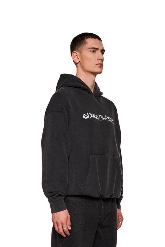 E.O.I Hoodie Black mit Ripp-Bündchen, Teilungsnähten, Kängurutasche und Siebdruck-Logo in Washed-Optik, lockere Passform, getragen von einem Mann.