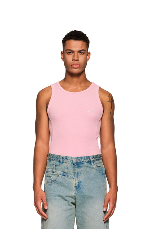 Mann trägt E.O.I Tanktop Cotton Candy in Pink mit OLAKALA-Logo auf der Brust, eng anliegend, zeigt Teilungsnähte an den Seiten, kombiniert mit blauen Jeans.