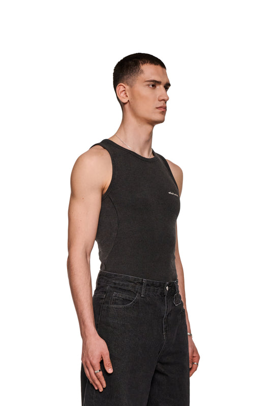 Mann in schwarzem E.O.I Tanktop mit gesticktem OLAKALA Logo auf der Brust, eng anliegende Passform, seitliche Teilungsnähte, in Washed-Optik.