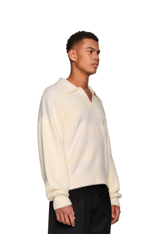 Mann trägt Glitched Fuzzy Polo Cream mit Polo-Kragen, gesticktem Synergy-Logo auf Brust, unisex, aus flauschigem Material, reguläre Passform.