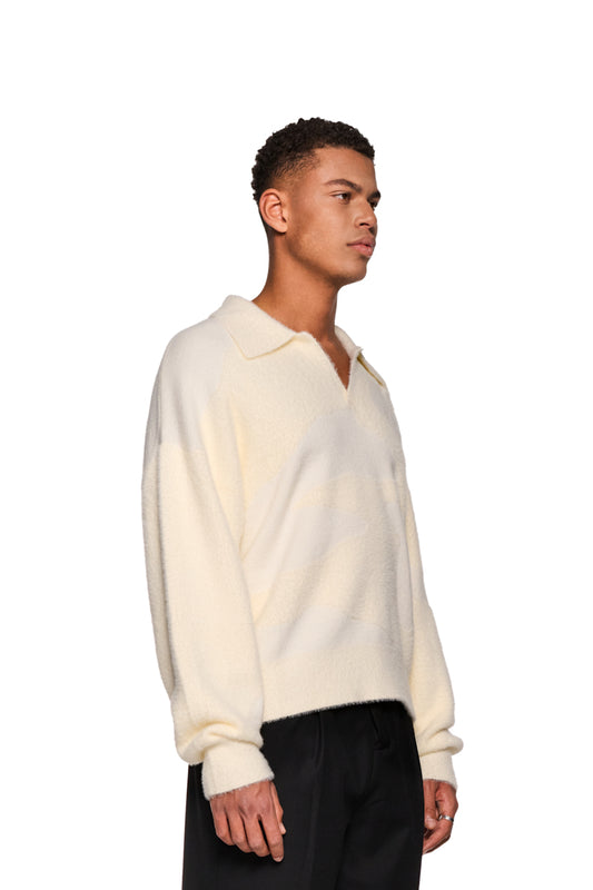 Mann trägt Glitched Fuzzy Polo Cream mit Polo-Kragen, gesticktem Synergy-Logo auf Brust, unisex, aus flauschigem Material, reguläre Passform.