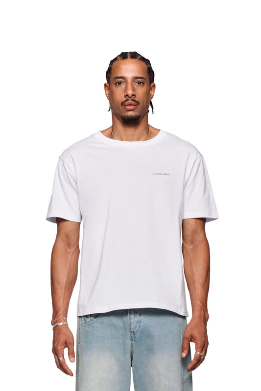 Mann in weißem CC T-Shirt Regular mit Ripp-Kragen und gesticktem OLAKALA Logo auf der Brust, kombiniert mit Jeans, reguläre Passform.