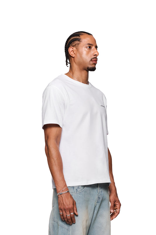 Mann trägt CC T-Shirt Regular White mit gesticktem OLAKALA Logo auf der Brust, Rippenkragen und regulärer Passform, ergänzt durch silberne Schmuckdetails.