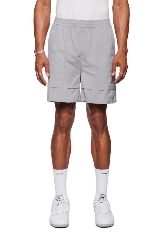 Mann in grauen Track Shorts mit elastischem Bund und französischen Taschen, trägt weiße Sneakers. Robustes Rip-Stop Gewebe, ideal für Alltag und vielseitige Nutzung.