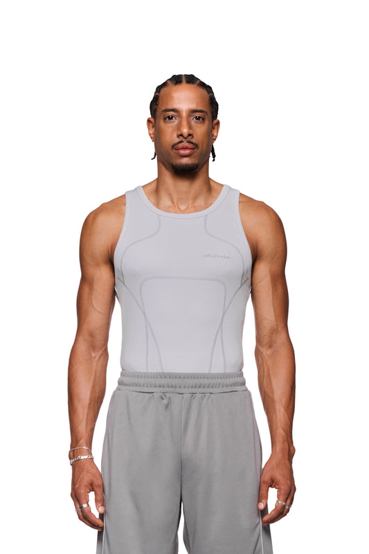 Mann trägt eng anliegendes Anatomy Tanktop Light Gray mit Ziernähten und gesticktem OLAKALA Logo auf der Brust. Unisex-Design, betont Schultern und Brust.