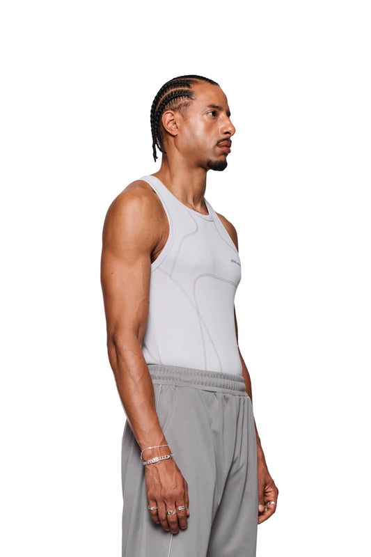Mann trägt das Anatomy Tanktop Light Gray mit Ziernähten und gesticktem OLAKALA Logo auf der Brust, eng anliegend, unisex.