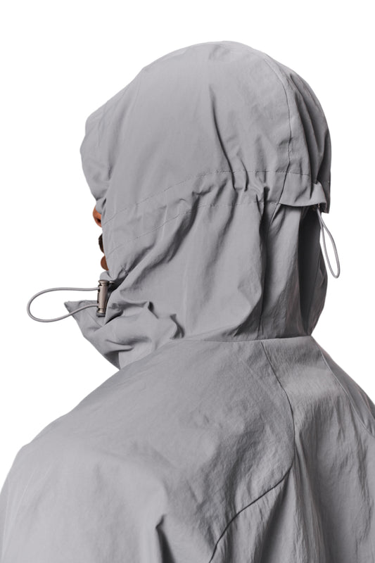 One person wears the Windbreaker Light Gray with hood and elastic details, ideal for wind and weather protection, with embroidered OLAKALA logo on the chest.