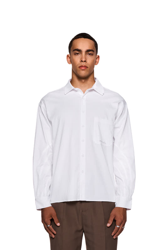 Man in white CC Anatomy shirt with button placket, double layer collar, chest pocket and embroidered OLAKALA logo, showing casual, unisex style.
