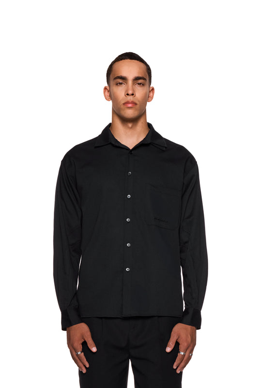 Mann trägt das CC Anatomy Shirt Black mit Knopfleiste und Brusttasche, locker geschnitten, unisex, gesticktes OLAKALA Logo sichtbar.