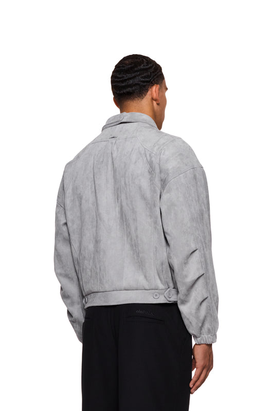 Mann in grauer CC Anatomy Velour Jacke mit doppeltem Kragen und asymmetrischem Rücken, zeigt seitliche Paspeltaschen und elastische Ärmelbündchen.