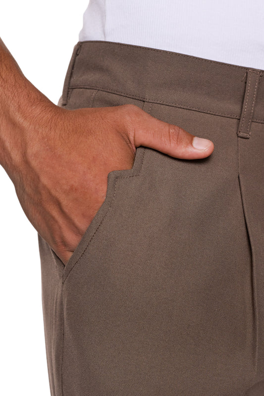 Nahaufnahme einer Hand in der Tasche der CC Dress Pants Regular Brown, zeigt französische Taschen und das gestickte OLAKALA Logo über der Gesäßtasche.