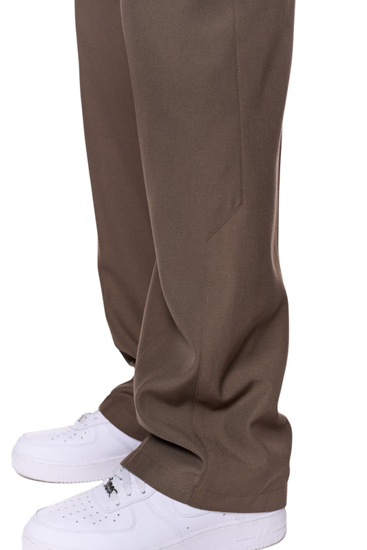 Beige CC Dress Pants Regular mit französischen Taschen und Bundfalten, getragen mit weißen Schuhen, präsentiert von OLAKALA.